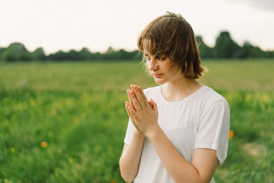 Teenager girl closed her eyes, praying. hands folded in prayer concept for faith