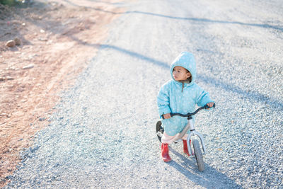 High angle view of boy riding bicycle on road