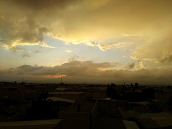 Silhouette buildings against sky during sunset