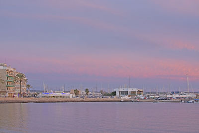 Sailboats in sea against sky during sunset