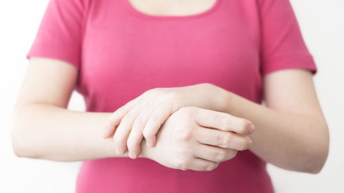 Close-up of hands against pink background