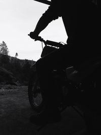 Low section of man riding bicycle on road