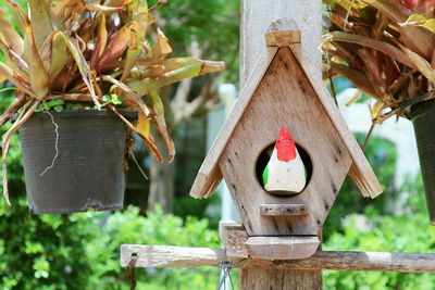 Close-up of birdhouse hanging on wooden post