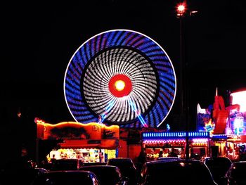Illuminated ferris wheel in city at night