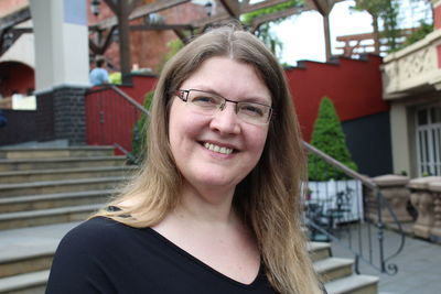 Portrait of smiling woman against house