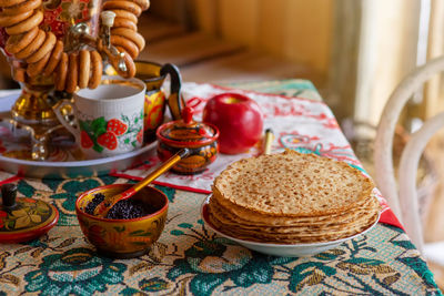 Traditional russian food,pancakes with caviar, stand on the table with a samovar
