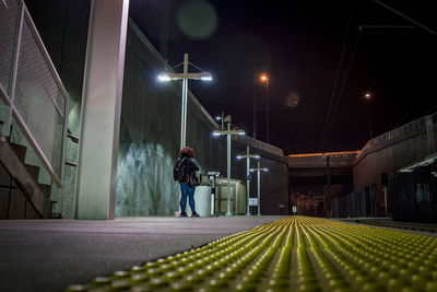 Rear view of woman standing at railroad station platform