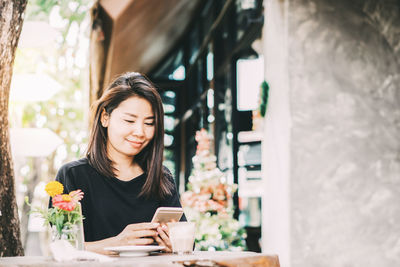 Young woman using mobile phone outdoors