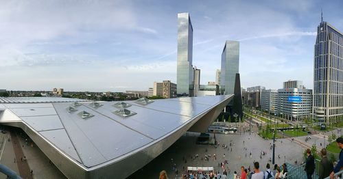 Crowd in city against sky