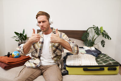 Portrait of senior man using phone while sitting on sofa at home