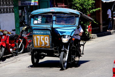 Man driving jinrikisha on city street