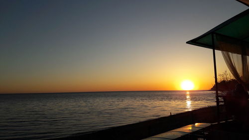 Scenic view of sea against clear sky during sunset