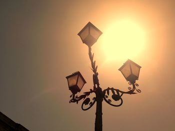 Low angle view of illuminated street light against sky during sunset