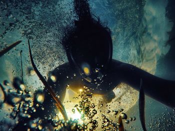 Person swimming in sea seen through glass