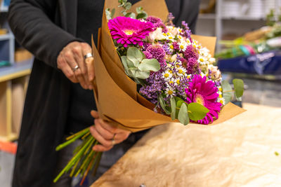 Midsection of bride holding bouquet