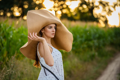 Young woman wearing hat standing outdoors