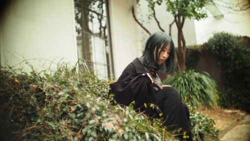 Side view of woman sitting on land