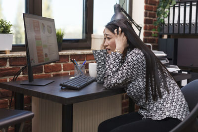 Young woman using laptop at cafe