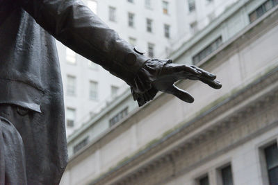 Low angle view of hand holding building in city