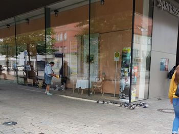 Rear view of people walking on street in city