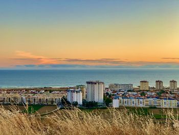 High angle view of sea and buildings against sky during sunset costa da caparica