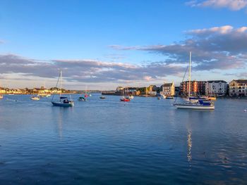 Sailboats moored on sea against sky