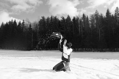 Playful woman playing with snowfield