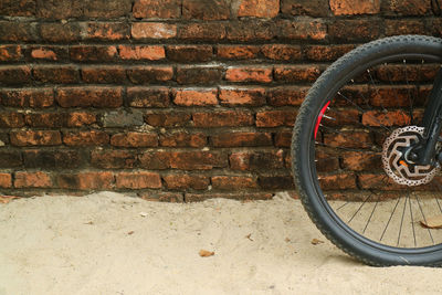 Close-up of bicycle on brick wall