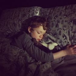 Cute boy relaxing on bed at home