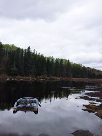 Boat moored on lake against sky