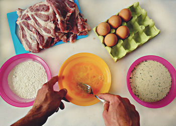 Cropped hand of man preparing food at table