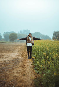 Woman standing on field against sky