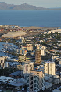 High angle view of city by sea against sky