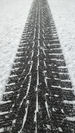 High angle view of tire tracks on snow covered land