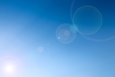 Low angle view of moon against blue sky