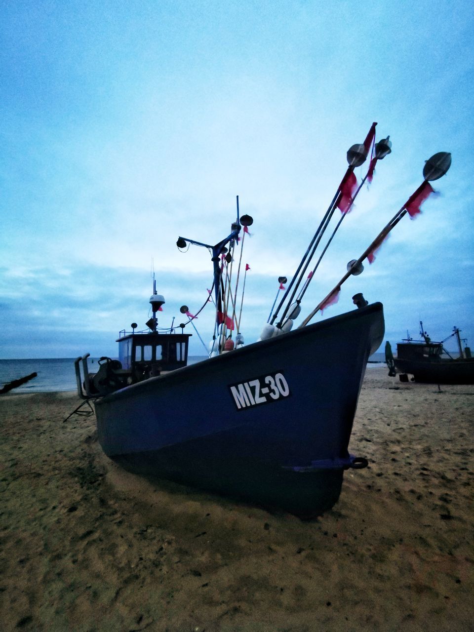 SHIP MOORED ON SHORE AGAINST SKY