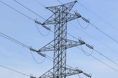 Low angle view of electricity pylon against clear sky