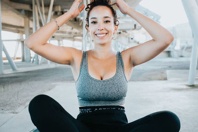 Portrait of young woman sitting on road