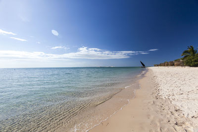 Scenic view of beach against blue sky