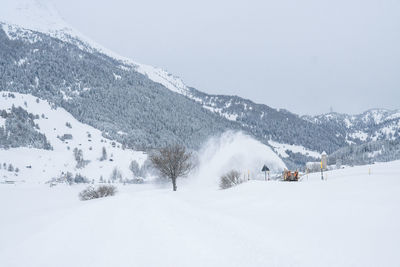 Ski lift on snowcapped mountains against clear sky