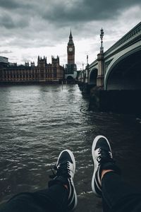 Low section of man by river against big ben