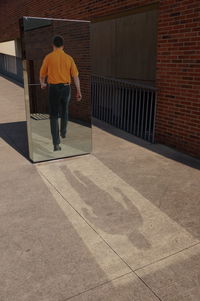 Rear view of man standing by building