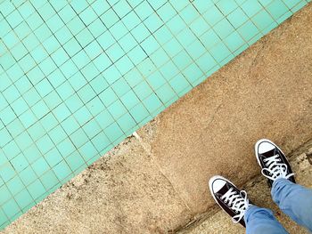 Low section of man standing at poolside