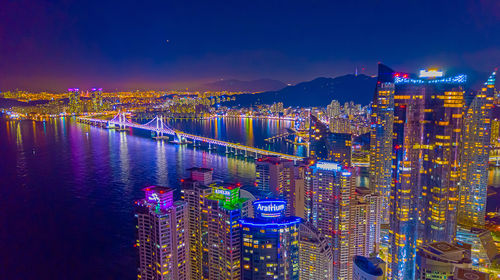 High angle view of illuminated buildings against sky at night