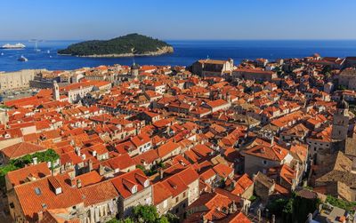 High angle view of town by sea against clear sky