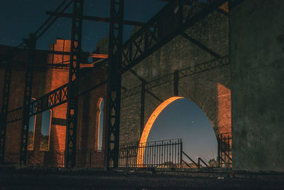 Arch of abandoned building against sky in city