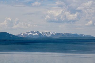 Scenic view of snowcapped mountains by sea against sky