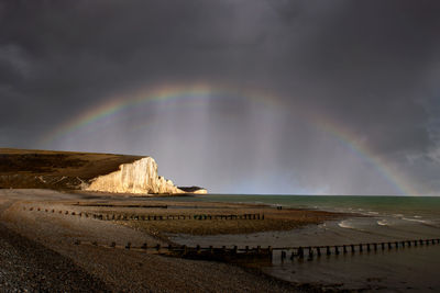 Scenic view of rainbow over sea against sky