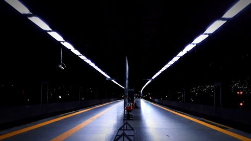 Illuminated railroad station platform at night