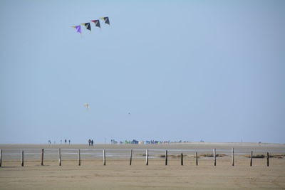 View of kites against clear blue sky